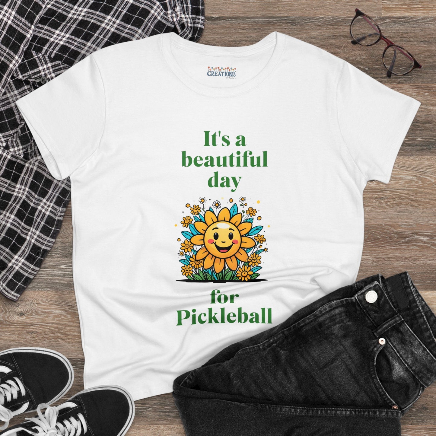 Women's Midweight Cotton Tee featuring a cheerful sun surrounded by flowers and the uplifting words, "It's a beautiful day for pickleball."