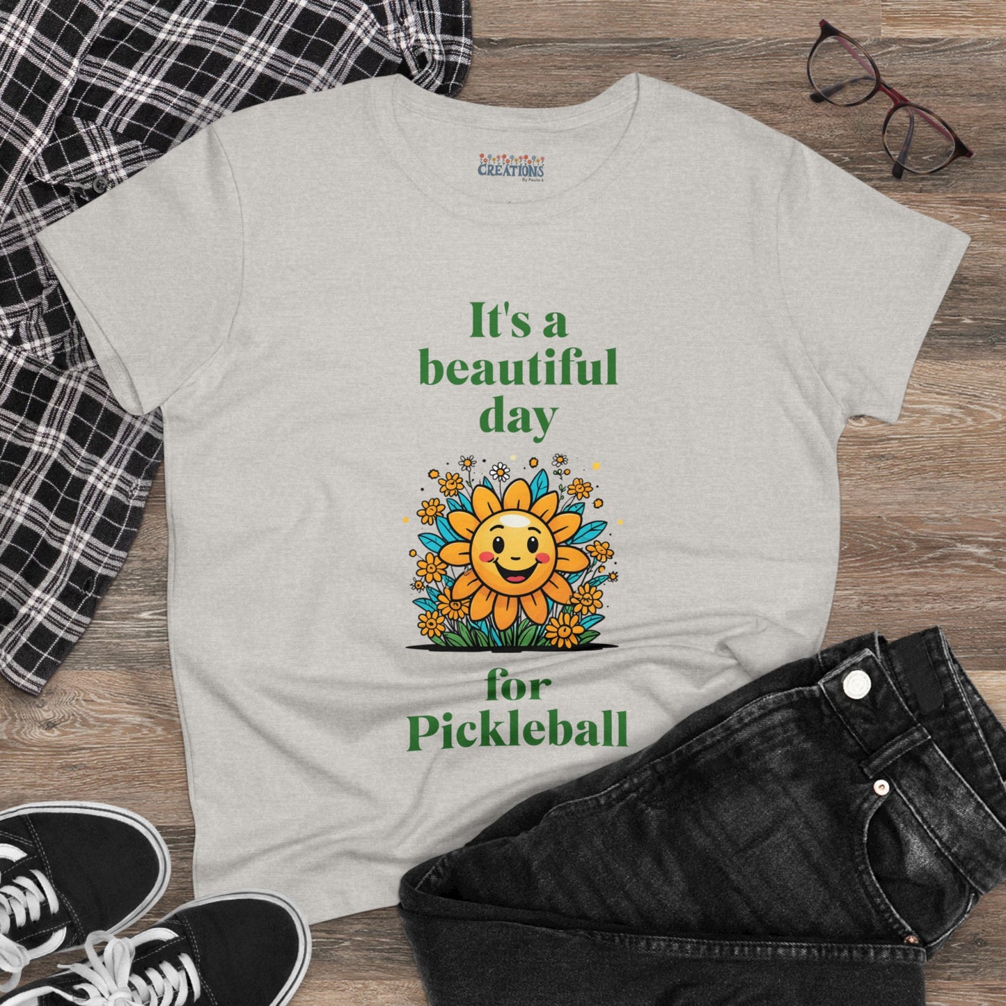 Women's Midweight Cotton Tee featuring a cheerful sun surrounded by flowers and the uplifting words, "It's a beautiful day for pickleball."