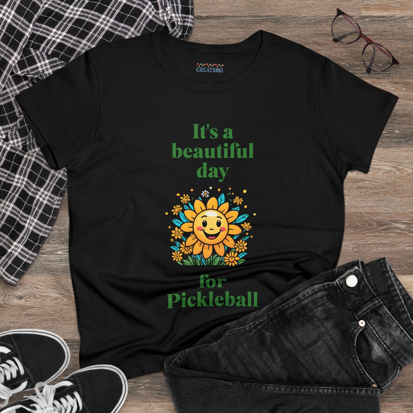 Women's Midweight Cotton Tee featuring a cheerful sun surrounded by flowers and the uplifting words, "It's a beautiful day for pickleball."