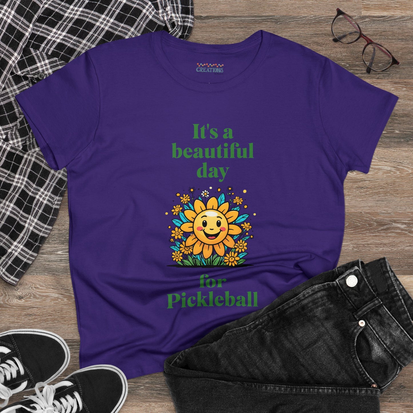 Women's Midweight Cotton Tee featuring a cheerful sun surrounded by flowers and the uplifting words, "It's a beautiful day for pickleball."